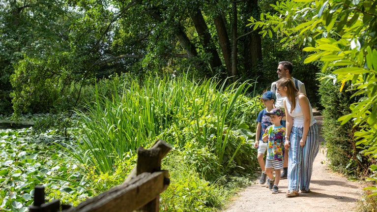 A family strolling by the lake at Baddesley Clinton, Warwickshire